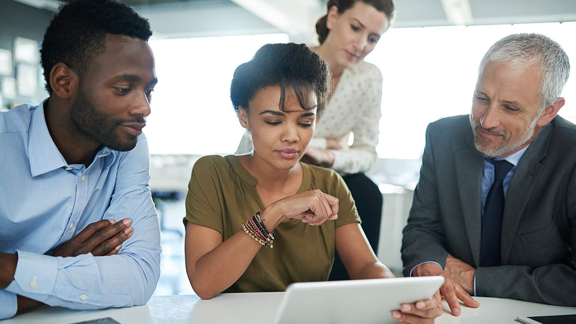 people in meeting looking at tablet